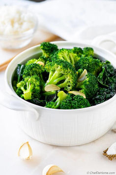 a white bowl filled with broccoli on top of a table