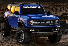 a blue truck parked on top of a dirt field