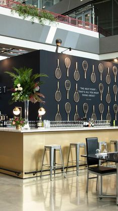 an empty restaurant with tables and chairs in front of a wall decorated with kitchen utensils