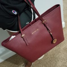 Maroon Mk Jet Set Bag With Gold Lettering. The Handbag Is New But There Are No Tags Attached. Classic Michael Kors Bag For Everyday Use, Classic Michael Kors Bag For Daily Use, Travel Tote Bag With Branded Hardware, Classic Michael Kors Shoulder Bag For Travel, Classic Michael Kors Bag For Everyday, Elegant Michael Kors Travel Bags, Michael Kors Tote Bag For Daily Use, Classic Michael Kors Tote Bag, Luxury Michael Kors Shoulder Bag With Large Capacity