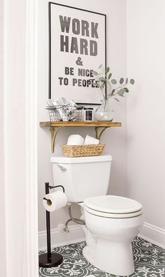 a white toilet sitting in a bathroom next to a wooden shelf