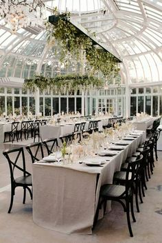 an indoor dining room with tables and chairs set up for a formal function in front of a large glass ceiling