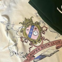 an image of a book club t - shirt on the bed with it's logo