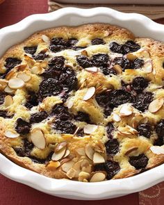 a pie with almonds and blueberries in a white dish on a red table cloth