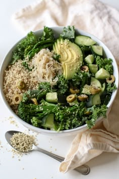 a white bowl filled with broccoli, cucumbers and other food items