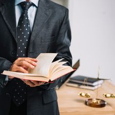 a man in a suit holding an open book