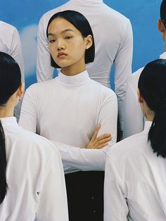 a group of young women standing next to each other in front of a blue wall