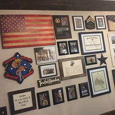 a wall filled with pictures and framed photos next to a fireman's flag