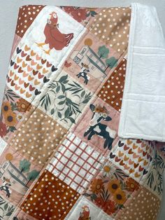 a close up of a patchwork quilt on a pillow with an animal and flower pattern