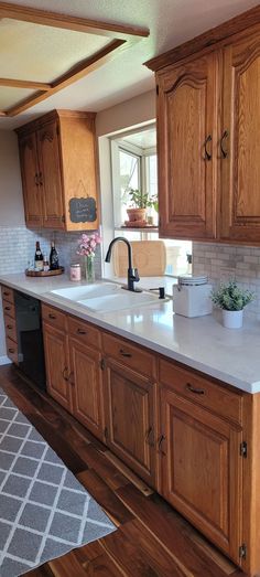 a kitchen with wooden cabinets and white counter tops