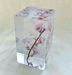 a clear vase with pink flowers on it