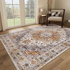 a large area rug with an ornate design on the floor in front of a window