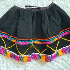 Mexican Embroidered Circle Skirt, Pull On, Tie Back, Never Worn, Fits A Small From Mexico Colorful Embroidered Trim No Zip Or Button Tie Back No Size Noted Traditional Embroidered Mini Skirt, Folk Style Embroidered Multicolor Skirt, Folk Style Multicolor Embroidered Skirt, Multicolor Embroidered Mini Skirt, Traditional Multicolor Embroidered Skirt, Black Cotton Skirt For Festival, Fitted Embroidered Cotton Skirt, Embroidered Mini Skirt For Festival, Traditional Mini Skirt With Lining