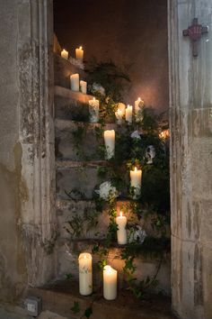 candles are lit in front of an open window with ivy growing on the outside wall