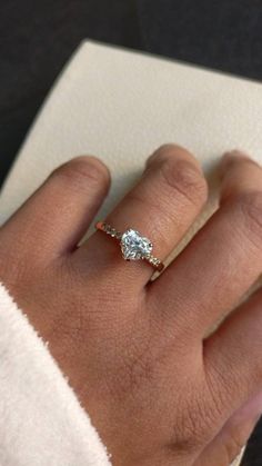 a woman's hand with a diamond ring on it