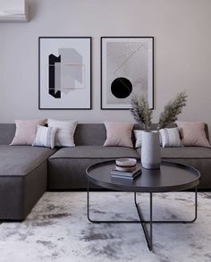 a living room with two pictures on the wall and a gray couch in front of it