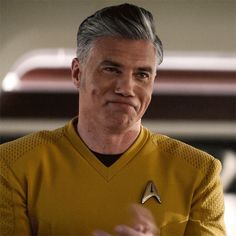 a man in a star trek uniform is talking to someone while holding his hand out