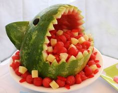 a watermelon shaped like a shark with its mouth open and some fruit in it