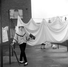 an old black and white photo of a woman holding a hairdryer in her hand