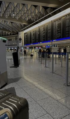 an airport terminal with people waiting for their luggage