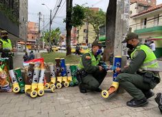 two police officers sitting on the ground next to some trash cans with dogs written on them