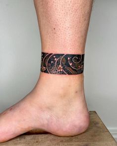 a close up of a person's bare foot with a tattoo on the ankle