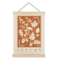 an orange and white wall hanging with autumn images on it, along with leaves and acorns