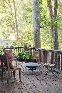 an outdoor deck with chairs, table and potted plants