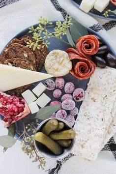 an assortment of cheeses and crackers on a plate