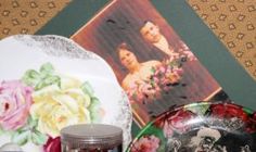 there are many plates on the table with flowers and pictures behind them in this photo