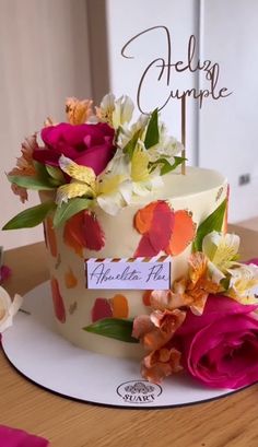 there is a cake with flowers on it and a name plate that says hello cupcake