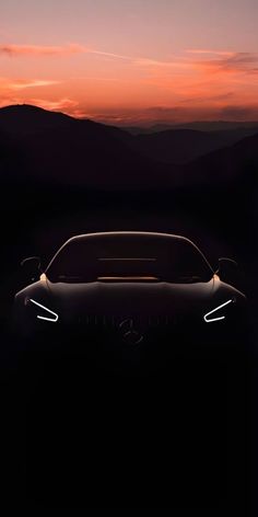 the mercedes concept car is shown at night with mountains in the backgrouund