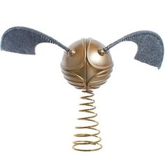 a golden metal object with two wings on it's head