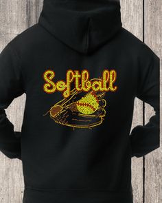 Softball Rhinestone Pullover Hoodie A classic black zip-up hoodie, featuring an Softball rhinestone design for sparkle lovers. This adorable design, gives you the perfect sparkle look for those who love hoodies, comfort and sparkle. Hoodie comes styled with the adorable Softball rhinestone design with a choice of on the front or back as featured in the photos. Designed with Topaz, Yellow and Red Rhinestones. Everyone has that one hoodie that they just can’t take off after they put it on. We use Sports Team Apparel, Topaz Yellow, Summer Clearance, Long Sleeve Outerwear, Black Zip Ups, Team Apparel, Rhinestone Designs, Red Rhinestone, Comforters Cozy