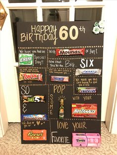 a birthday chalk board with candy bars on it in front of a door that says happy 60th