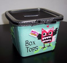 a lunch box with an owl design on the front and bottom, sitting on a table