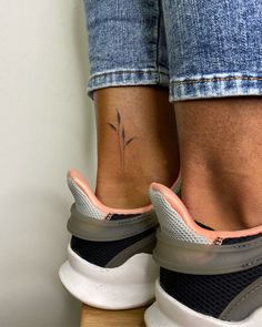 a woman's foot with a flower tattoo on her left ankle and right leg