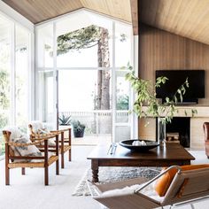 a living room filled with furniture and a flat screen tv on top of a wooden table