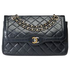 Chanel​ ​Diana​ ​double​ ​flap​ ​shoulder​ ​bag​ ​in​ ​black​ ​quilted​ ​lambskin​ ​leather,​ ​gold-tone​ ​metal​ ​hardware,​ ​a​ ​gold-tone​ ​chain​ ​strap​ ​intertwined​ ​with​ ​black​ ​leather​ ​for​ ​shoulder​ ​or​ ​crossbody​ ​carry Back​ ​pocket​ ​on​ ​the​ ​bag​ ​CC​ ​logo​ ​closure​ ​in​ ​bicolored​ ​metal​ ​(gold​ ​and​ ​silver) on​ ​the​ ​flap​ ​Interior​ ​lined​ ​in​ ​burgundy​ ​leather,​ ​with​ ​one​ ​zip​ ​pocket,​ ​one​ ​double​ ​slip​ ​pocket,​ ​and​ ​one​ ​lipstick​ ​holder Signature:​ ​"Chanel​ ​Paris®​ ​Made​ ​in​ ​France" Date:​ ​Prior​ ​to​ ​1986,​ ​before​ ​the​ ​introduction​ ​of​ ​holograms​ ​ Dimensions:​ ​26x18x7​ ​cm​ ​(10.2x7x3​ ​inches)​ ​ Chain​ ​length:​ ​40​ ​cm​ ​(18​ ​inches) Reference:​ ​102027 Packaging:​ ​ Hologram:​ ​No​ ​ Authenticity​ ​card:​ ​No​ ​ D Channel Purse, Vintage Chanel Bag, Structured Shoulder, Chanel Brand, Chanel Flap Bag, Flap Shoulder Bag, Lipstick Holder, Chanel Paris, Black Quilt