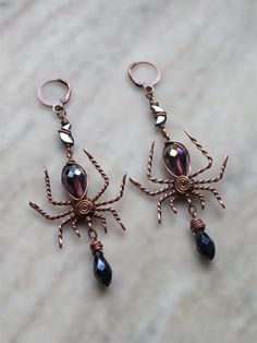 creepy, fancy spider earrings for the witch or lover of halloween season and creepy crawlies in your life!  made with solid, twisty antiqued copper wire, a faceted purple glass teardrop bead for the body, faceted dark navy blue glass briolettes hanging below  & lil hematite moons connecting the spiders to the hook✨ spider width is about 1.35" at widest part, drop length is about 2.5" and these are very lightweight for their size!  choose your hypoallergenic hooks :) Halloween Vampire Metal Earrings, Vampire Style Metal Earrings For Halloween, Handmade Black Fantasy Earrings, Witchy Metal Earrings For Halloween, Witchy Metal Halloween Earrings, Handmade Witchy Earrings For Halloween, Spooky Handmade Earrings For Halloween, Gothic Halloween Earrings Gift, Halloween Fantasy Dangle Earrings