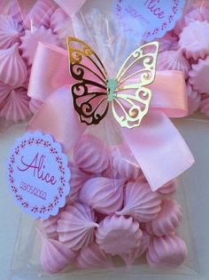 pink and gold butterflies in a clear bag with name tags on the front for favors