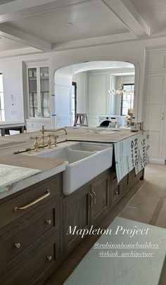 a large kitchen with an island sink and marble counter tops in the middle of it