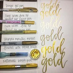 an image of some writing on paper with gold foil and pens next to each other