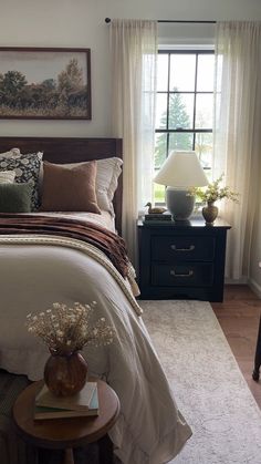 a bedroom with a bed, nightstands and window in it's center area