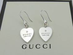 Brand: Gucci Material: 925 Sterling Silver Heart Size: Width 14 mm, Height 16 mm Hallmarks: Gucci / Made in Italy / Ag 925 Stunning square dangle earrings made by Gucci. This pair of earrings is in good condition. Some minor scratches.  They have been professionally polished. A great gift for your loved one. Gucci box (has minor signs of use) included. The earrings are hallmarked and guaranteed 100% authentic. The earrings have been authenticated by a professional before sale. 100% money back gu Classic Sterling Silver Earrings For Mother's Day, Luxury Heart Cut Sterling Silver Earrings, Luxury Sterling Silver Heart Earrings For Anniversary, Luxury Sterling Silver Heart Cut Earrings, Designer Pierced Jewelry As A Gift, Designer Silver Jewelry With Hallmarks, Designer Pierced Jewelry For Gifts, Designer Dangle Earrings For Gift, Luxury Silver Heart Earrings In Sterling Silver