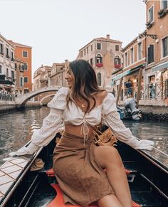 a woman sitting on the back of a boat in venice