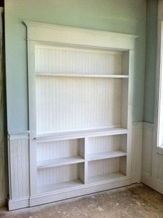 a white bookcase in the corner of a room