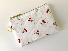 a white zippered pouch with cherries on it