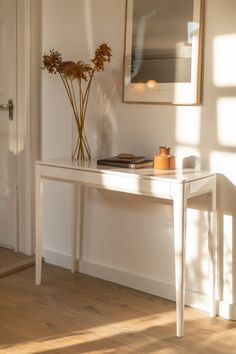 Warm sunlight bathes a minimalist white console table in a modern farmhouse chic living room, enhancing the serene décor.