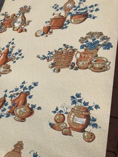 a table cloth with teapots and flowers on it